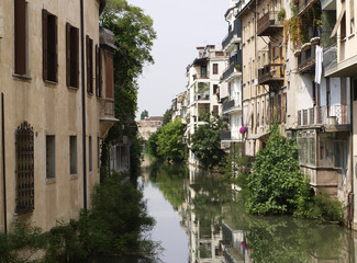 Fototapeta na wymiar Cityscape of canal in Padova, ltaly with brown houses