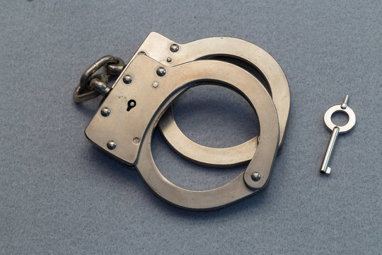 Metal Handcuffs on Gray Background