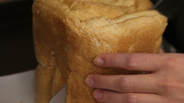 Man is cutting freshly cooked bread by knife