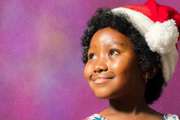 Black girl wearing christmas hat looking at corner.