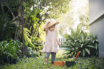 Fototapeta na wymiar Cute little girl having fun at countryside. Portrait of a boy or girl working in the garden in holiday