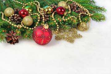 Christmas decorations and spruce branch and cones on a white