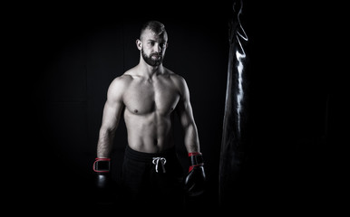 Fototapeta na wymiar Male Athlete boxer punching a punching bag with dramatic edgy li