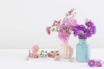 flowers in ceramic vases on white background