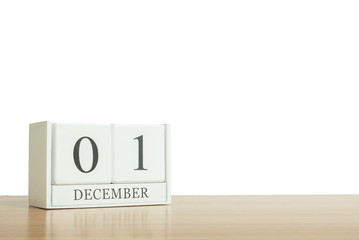 Closeup surface white wooden calendar with black 1 december word on blurred brown wood desk isolated on white background with copy space , selective focus at the calendar