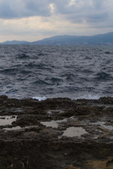 Fototapeta premium Dark view of coast. Water splashing on rocks.