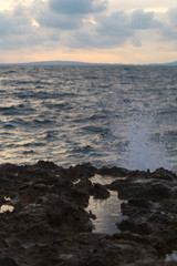 Water splashing on rocks coast. Sea background.