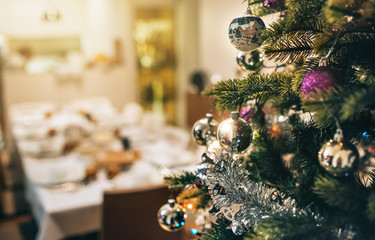 Decorated Christmas tree with dining table in background