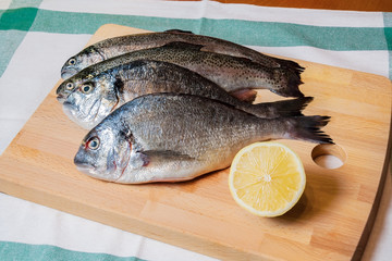 Fresh fish on wooden cutting board
