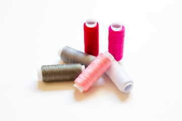 multicolored spools of thread on white background