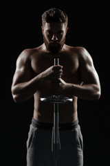 Portrait of naked athletic man with barbell