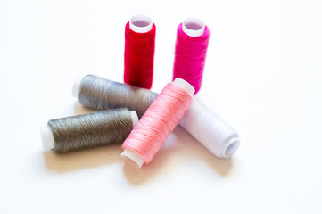 multicolored spools of thread on white background