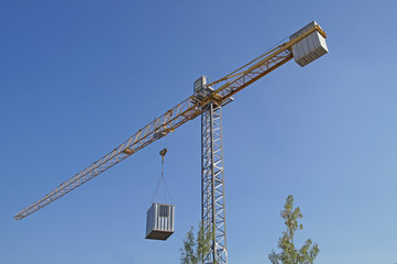 Crane at a construction site with  container suspended