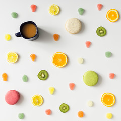 Colorful bright fruit pattern with coffee mug and sweets on whit