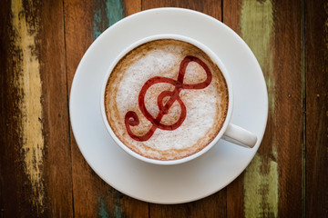 cup of coffee latte art on the wooden desk