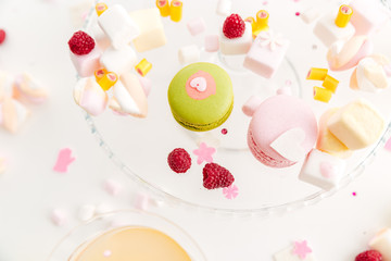 Closeup of french macaroons, marshmallows and berries on the plate
