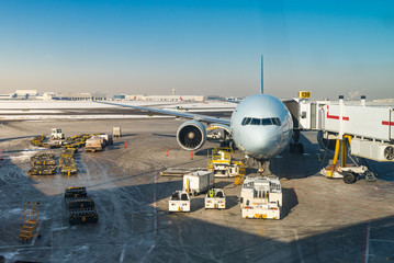 large airliner at gate with ground equipment