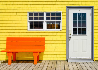 orange bench in front of yellow wood building