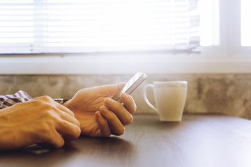 Close up of male hands using smart phone on the desk