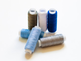 multicolored spools of thread on white background