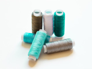 multicolored spools of thread on white background