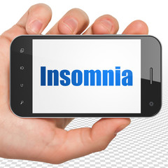 Healthcare concept: Hand Holding Smartphone with Insomnia on display