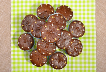 Chocolate muffins in a cute holder.A pile of cacao muffins with candy on top.