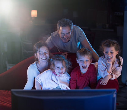 At Home By Night, A Family Watching A Funny Movie On Tv.
