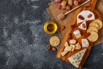 Assortment of cheese with honey, nuts and grape 
