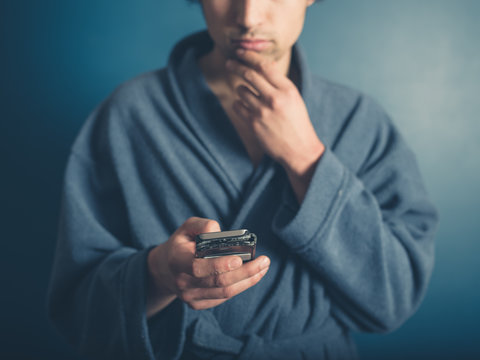 Man in bathrobe using smartphone