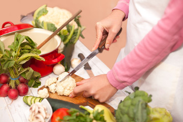Cutting of raw cauliflower on chopping board