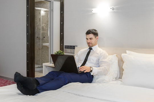 Young businessman working in his hotel room with his laptop
