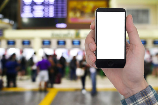 Male hands holding smart phone with touch blank white screen on blurred image of people buy ticket at the counter background.