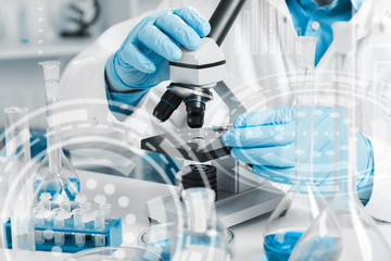 Fototapeta premium men in a laboratory microscope with microscope slide in hand