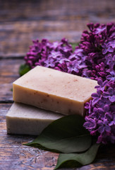 Spa set, handmade soap, a bouquet of lilacs on a wooden background