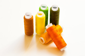 multicolored spools of thread on white background