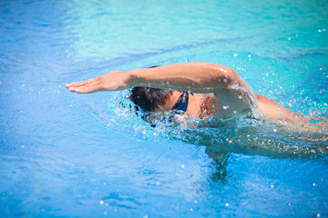 Young man swimming the front crawl/freestyle in a pool