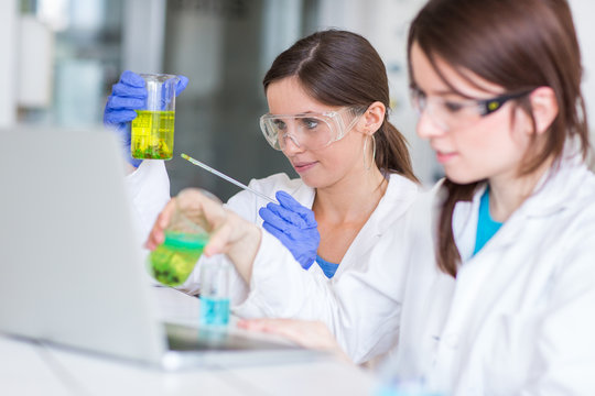 Two young female researchers carrying out experiments in a lab