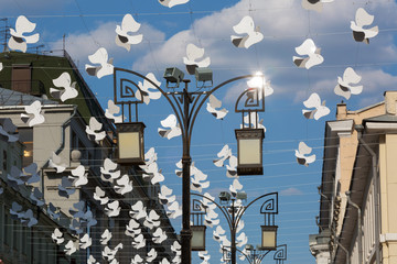 Street decorated with lots of white paper birds
