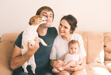 Family close-up portrait - parents, their little cute baby girl and their pet - jack russel terrier...