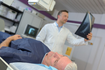 Obraz premium doctor checking xray of a senior patient in hospital