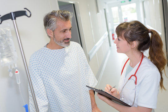 female doctor interacting with patient in hospital corridor