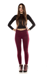 Fototapeta premium young model in burgundy pants and a black blouse on a white background