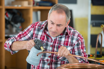 worker using blowtorch for soldering copper fittings