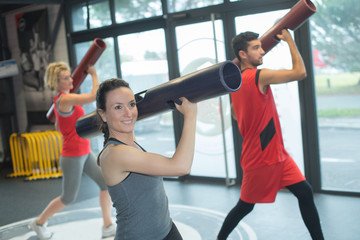 sportsmen exercising with bars in gym