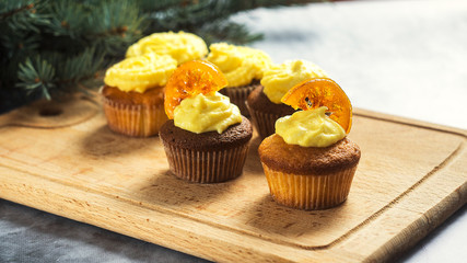 Tasty cupcakes with caramelized orange on table close-up