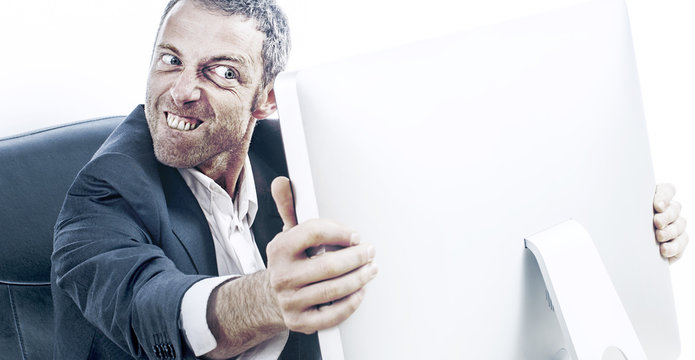 enraged businessman with bulging eyes and teeth holding computer