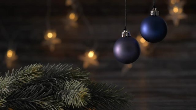 Two blue Christmas ball and spruce branches on the background of beautiful bokeh.