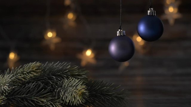 Two blue Christmas ball and spruce branches on the background of beautiful bokeh.