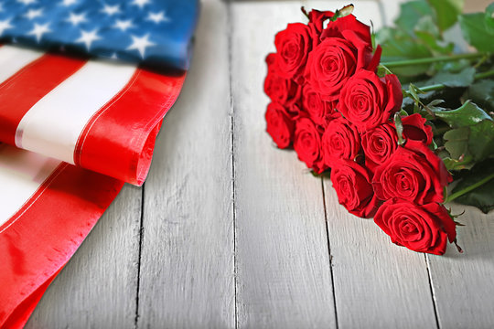 Roses and USA flag on wooden background. Symbol of America